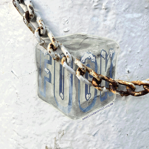 Rust-covered chain attached to a metal block with an ice cube sticker that says 'FUCK' on a textured surface.