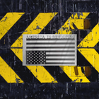 American flag with 'America is Revolting' text on a black and yellow striped background