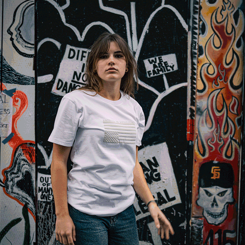 Person wearing a t-shirt with an upside-down American flag design that says America is Revolting