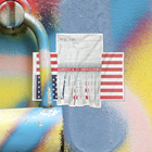 Graffiti with an upside down flag sticker with America is Revolting text on a colorful background