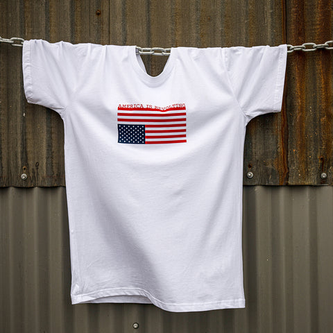 White t-shirt with an upside-down American flag design that says America is Revolting